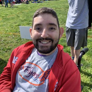 Smiling young man with a beard and red jacket