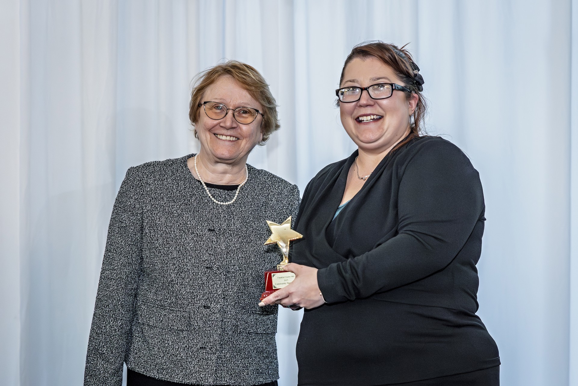 Smiling young woman accepts Community Star Award