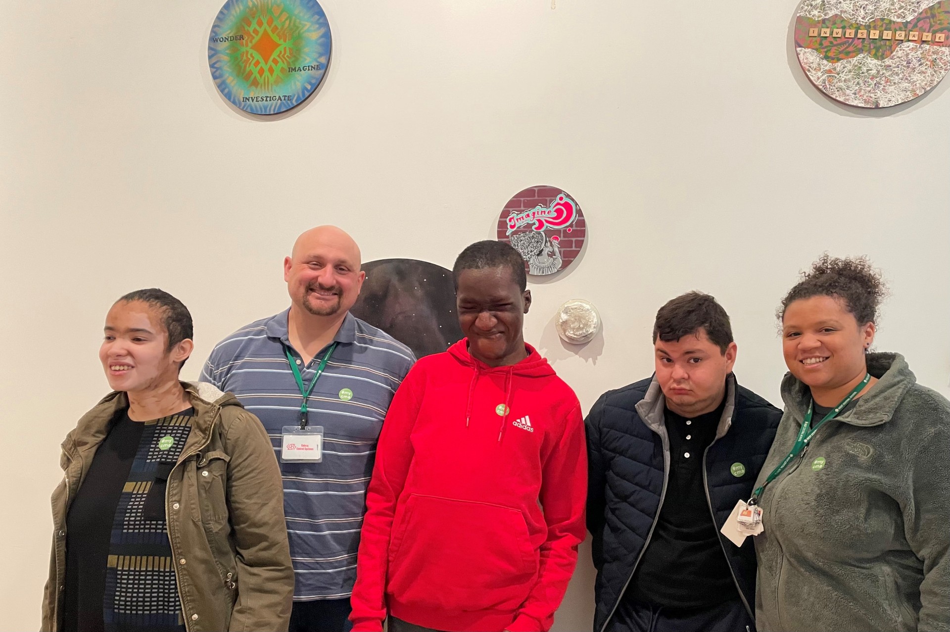 Group of three students and two teachers standing in front of a wall at the Columbus Museum of Art